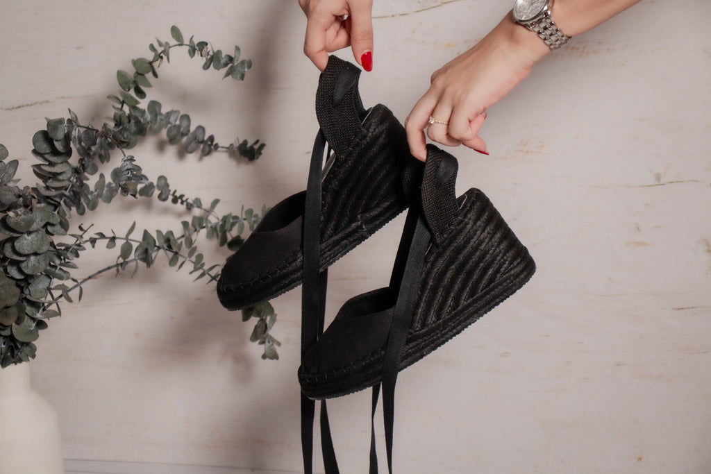 Detalle de las espadrilles Myriam sostenidas en la mano mostrando la cuña de yute y lona.