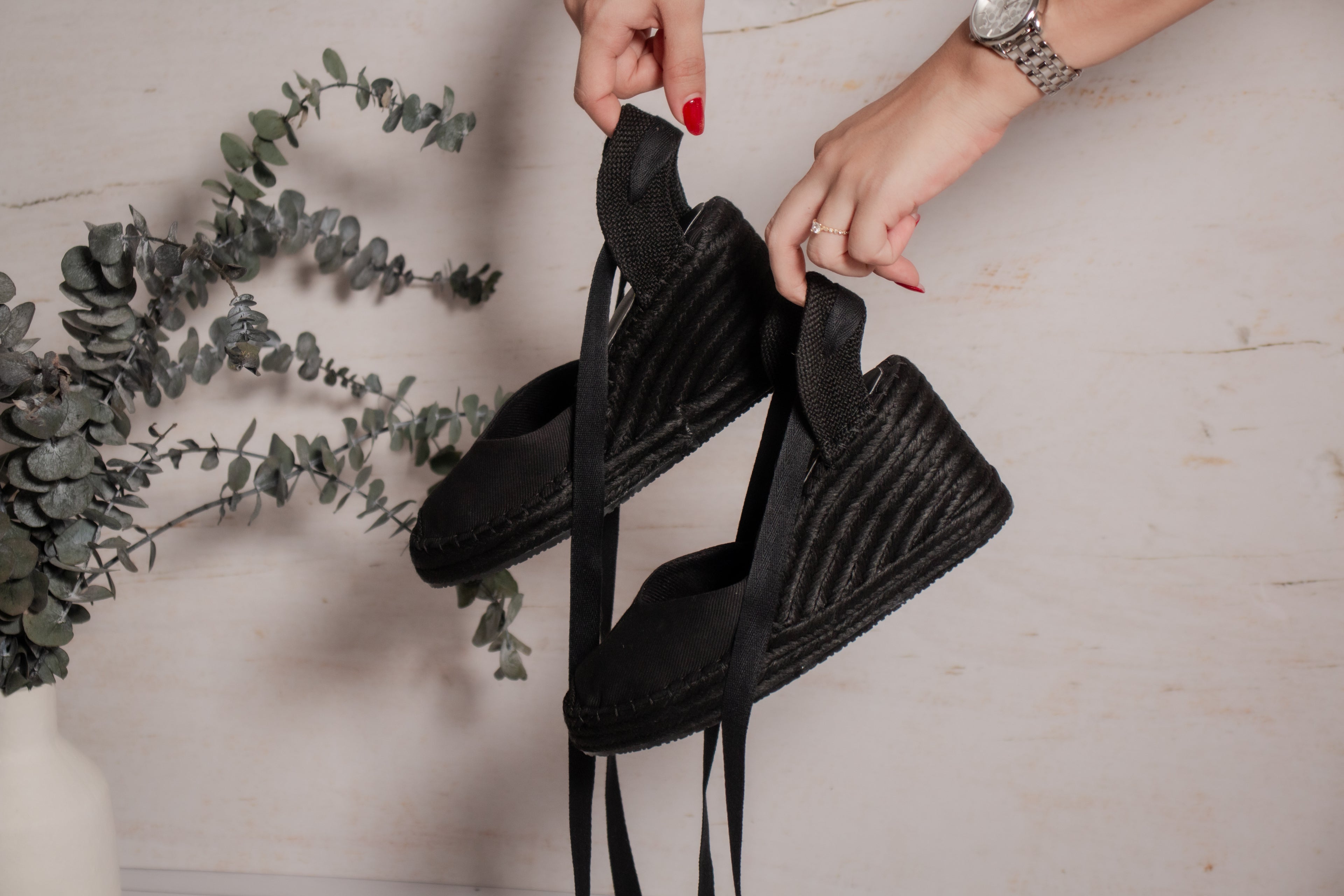 Detalle de las espadrilles Myriam sostenidas en la mano mostrando la cuña de yute y lona.