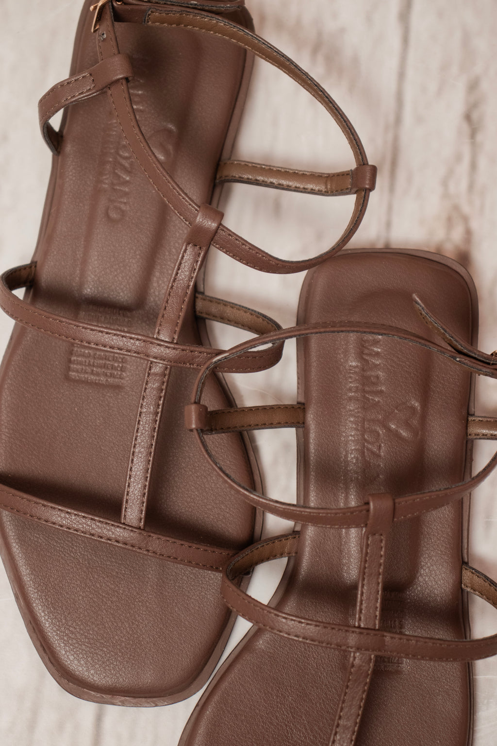 Primer plano del sistema de ajuste con hebilla metálica en las sandalias de tiras finas Amelia.