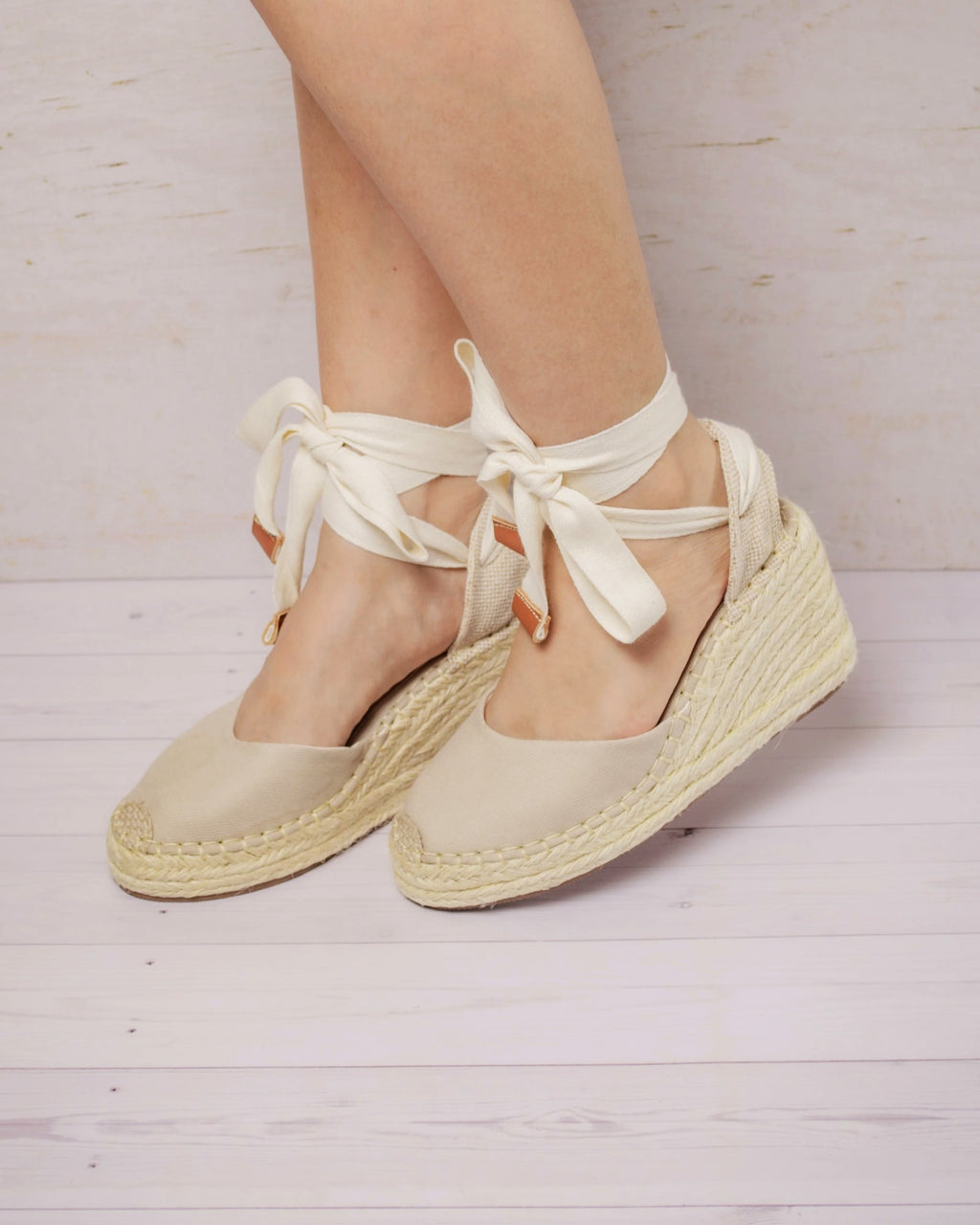Espadrilles Mireya beige puestas con cintas al tobillo