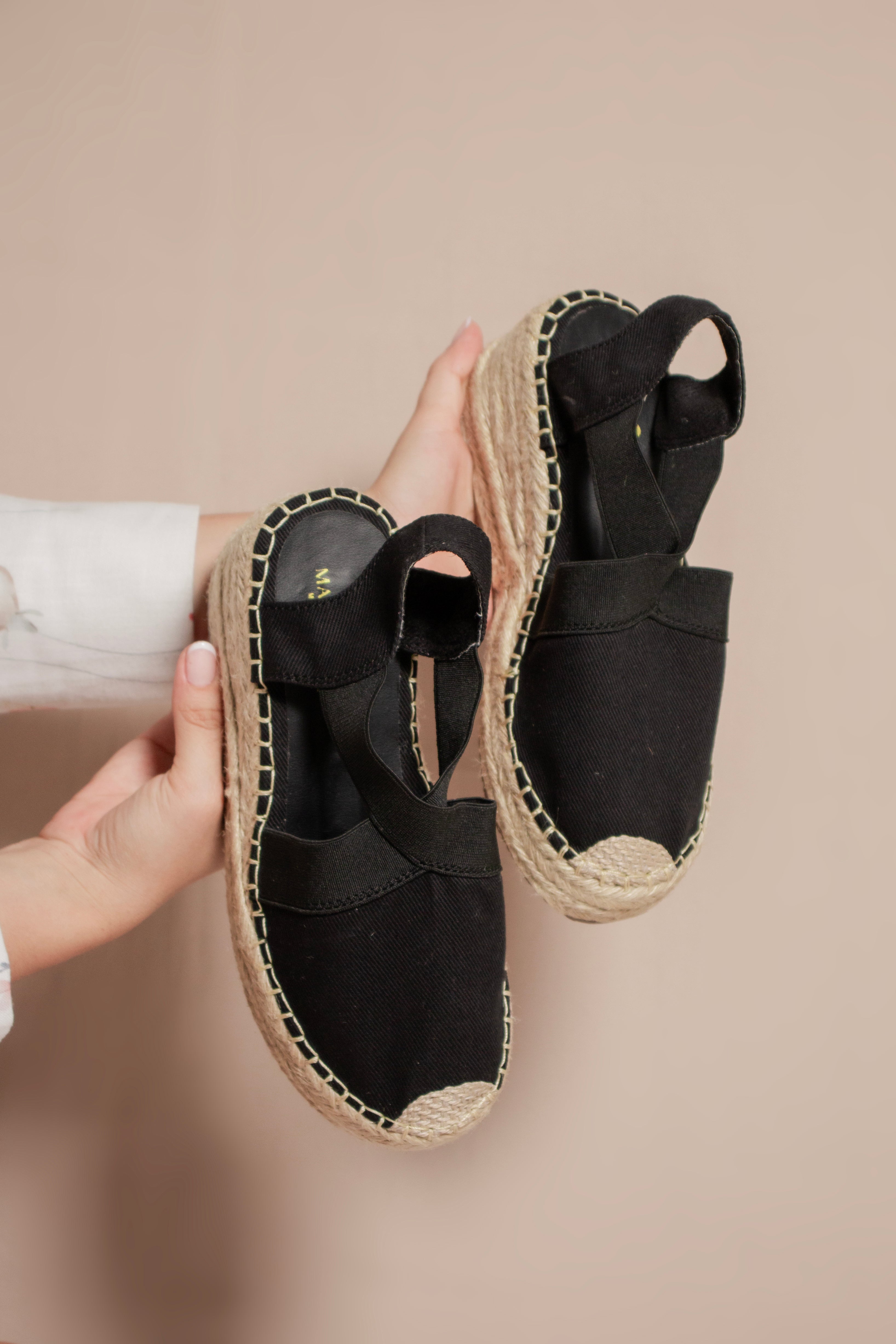 Primer plano de la punta tejida artesanalmente en las espadrilles negras Aurora.